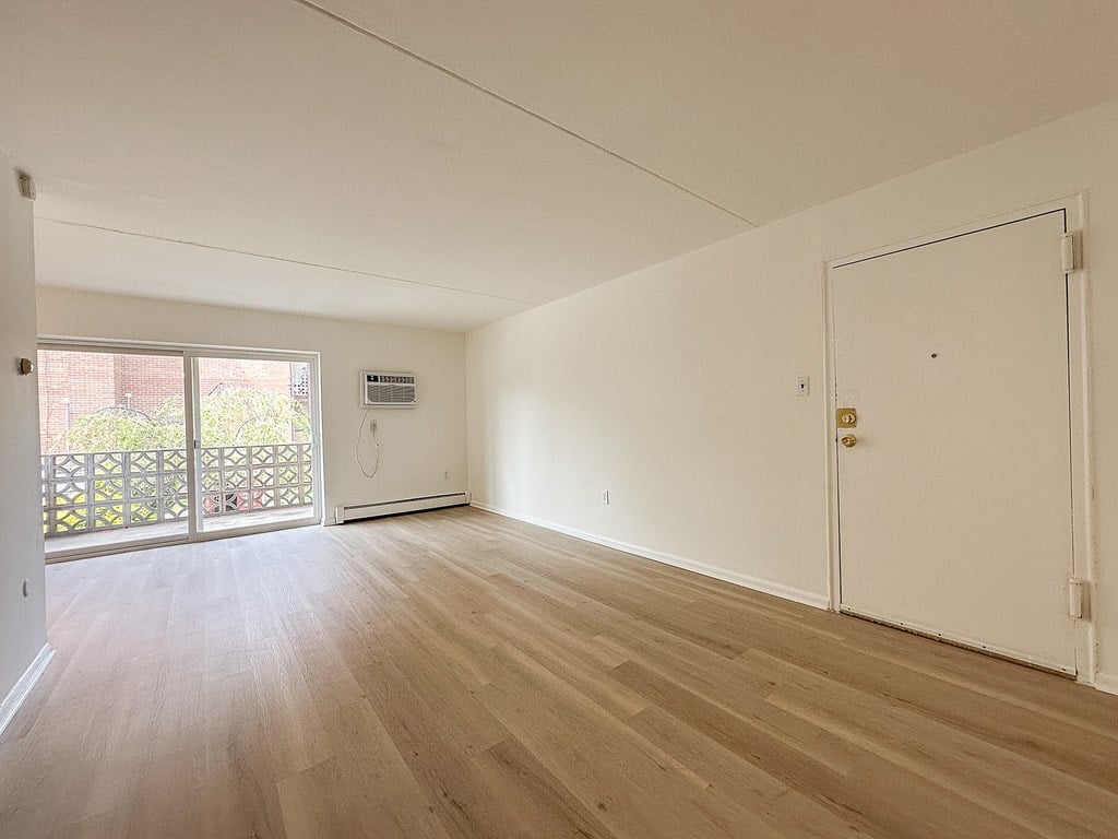 A room with wooden flooring and white walls.