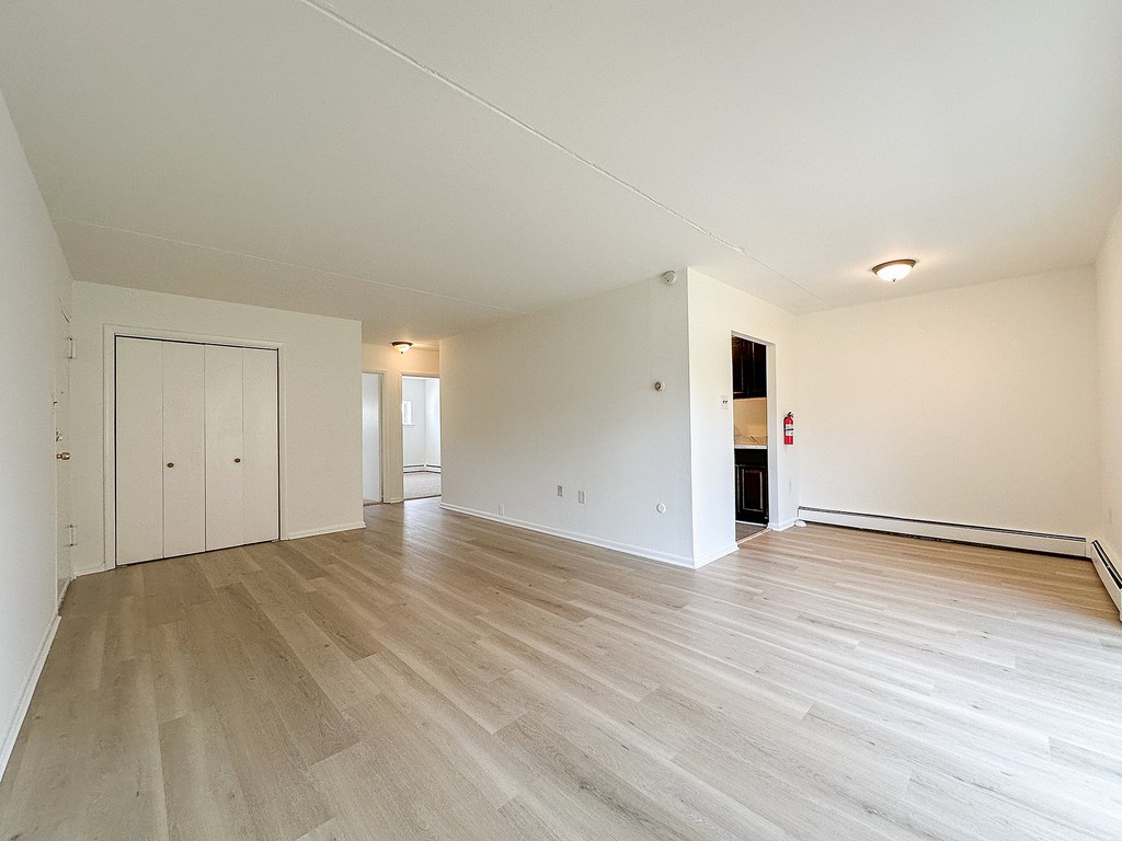 A large empty room with wooden floors and white walls.