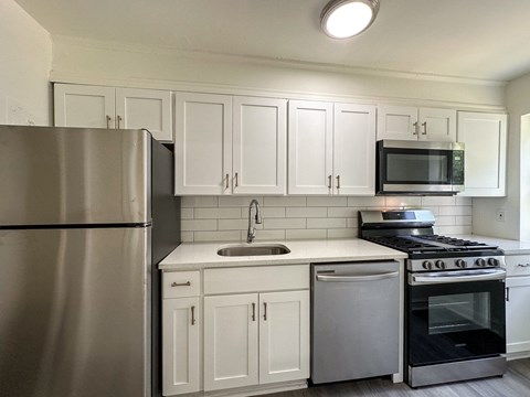 A kitchen with white cabinets and stainless steel appliances.