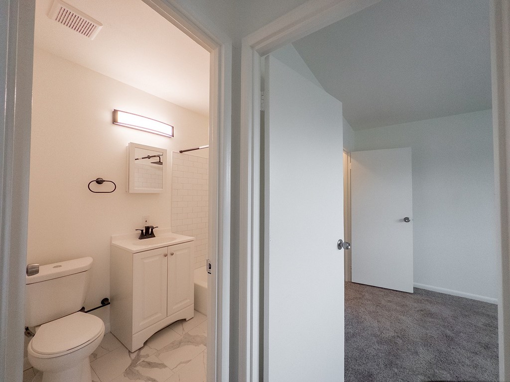 A white bathroom with a toilet, sink, and bathtub.