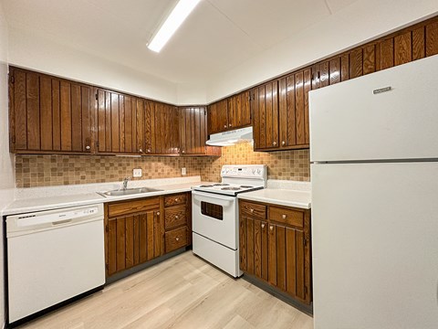 A kitchen with wooden cabinets and white appliances.