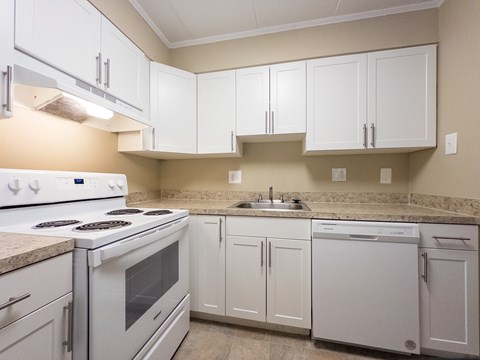 A kitchen with white cabinets and appliances.