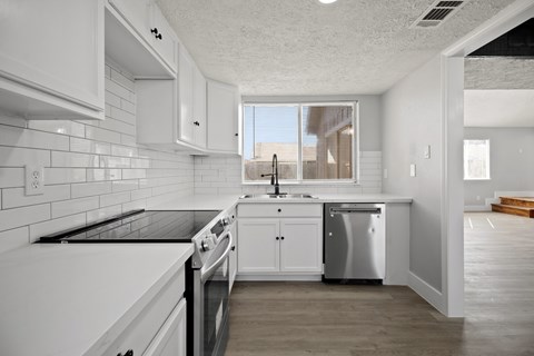 A modern kitchen with white cabinets and appliances.