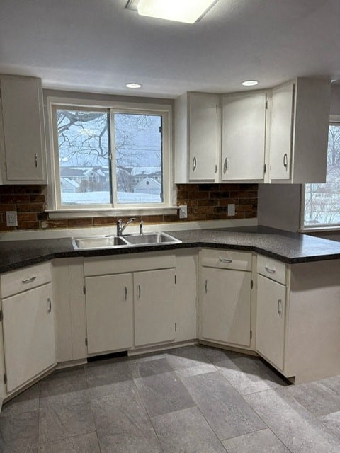 A kitchen with white cabinets and a black countertop.