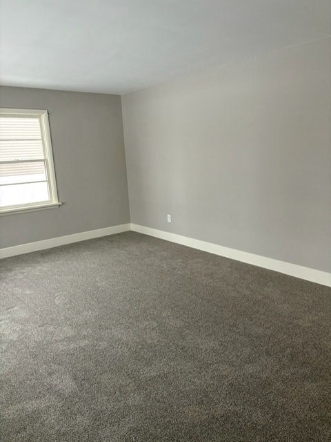 A room with a carpeted floor and a window.