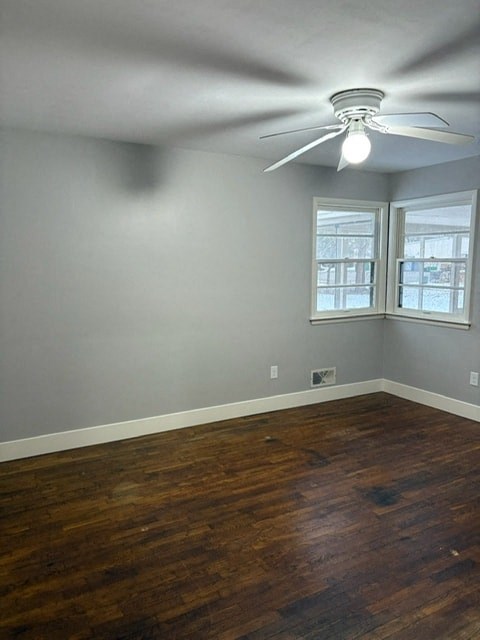 A room with a ceiling fan and wooden flooring.