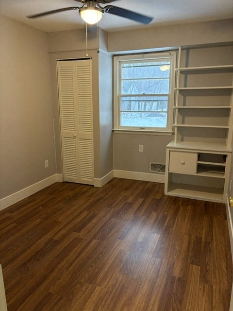 A room with wooden floors and a window with blinds.
