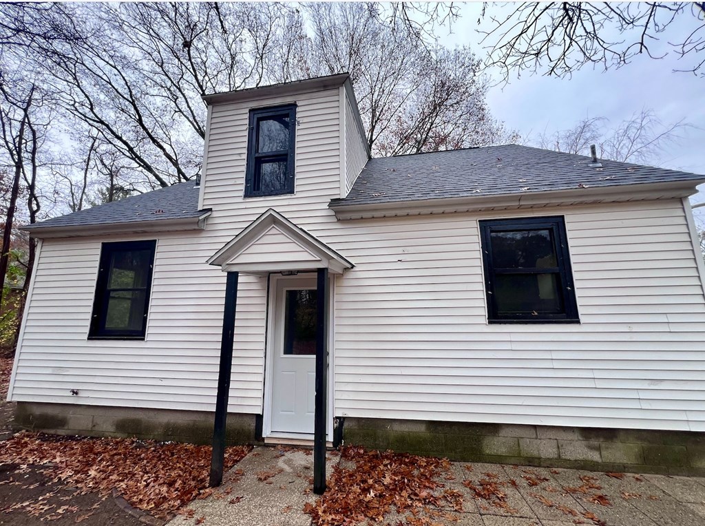 A white house with a black door and windows.