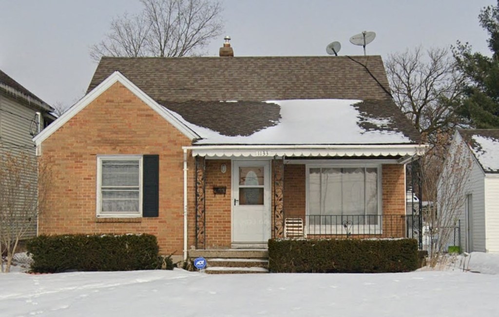 A small house with a white door and a brown roof.