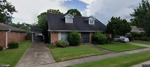 A house with a brick facade and a black roof.