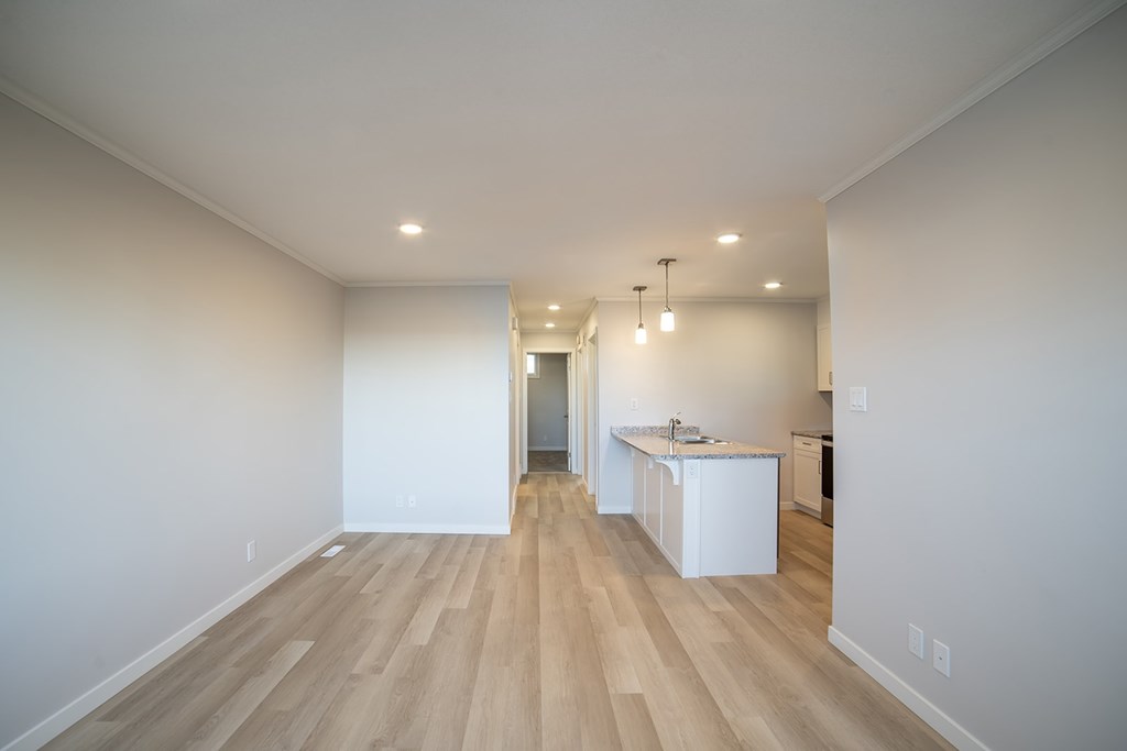 A kitchen area with a white counter and a white fridge.
