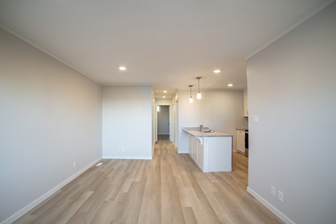 A kitchen area with a white counter and a white fridge.