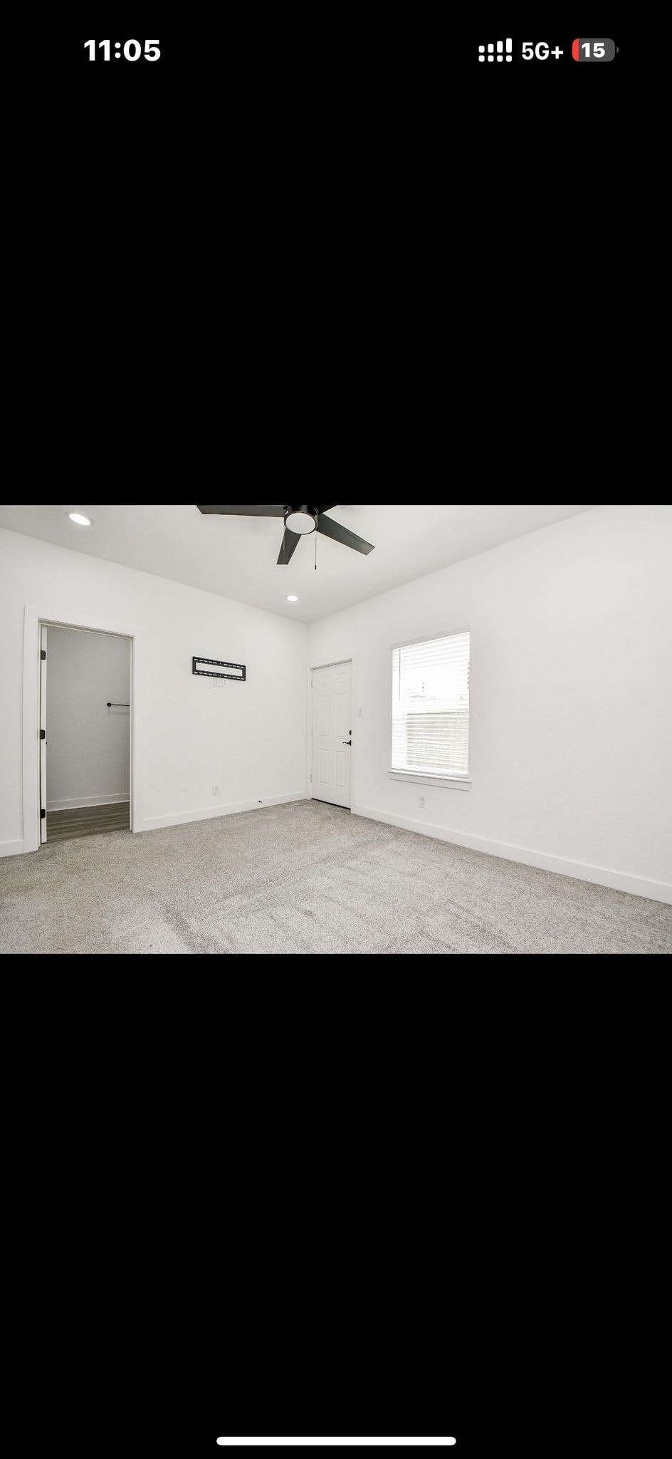 A room with a ceiling fan and a door.
