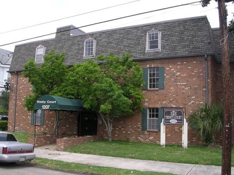 A brick building with a green awning that says "Pinety Court" on it.