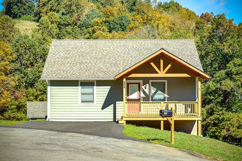A small house with a porch and a mailbox on it.