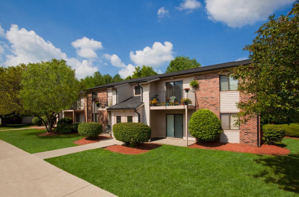 A residential building with a green lawn in front.