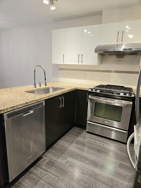 A modern kitchen with a stainless steel dishwasher and oven.
