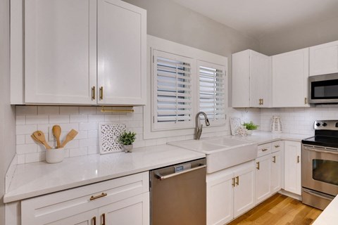 A kitchen with white cabinets and a stainless steel dishwasher.