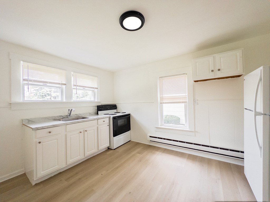 A row of houses with green grass in front.
