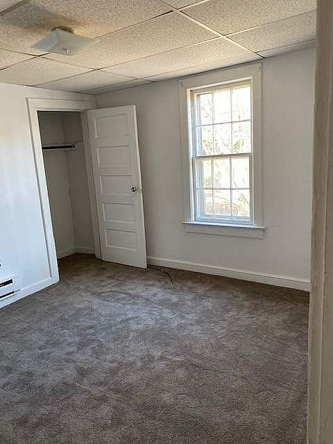A room with a carpeted floor and a window.