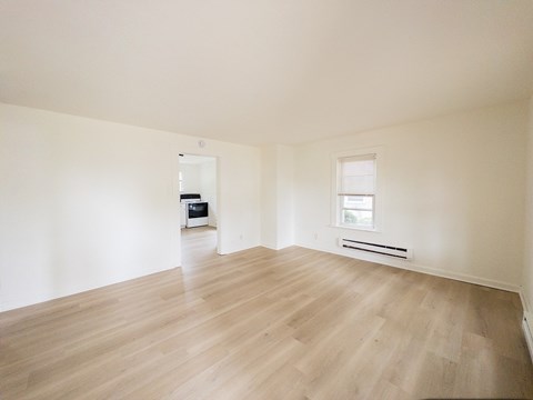 A room with a carpeted floor and a window.