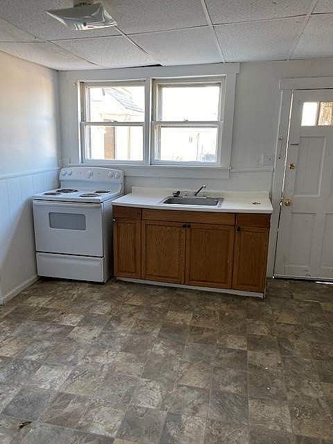 A kitchen with a white stove and a window.