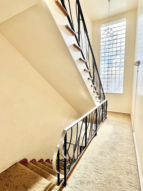 A staircase with a metal railing and wooden steps.