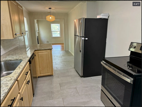 A kitchen with a black refrigerator and stove.