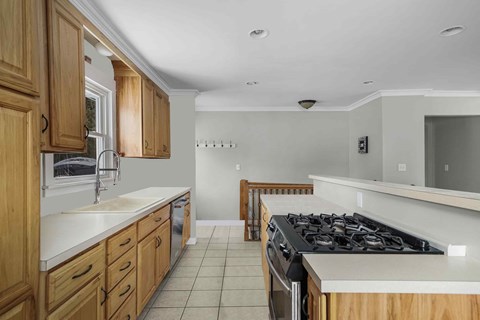 A kitchen with wooden cabinets and a black stove top.
