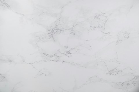 A close up of a white marble surface with natural veining.