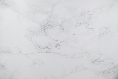 A close up of a white marble surface with natural veining.