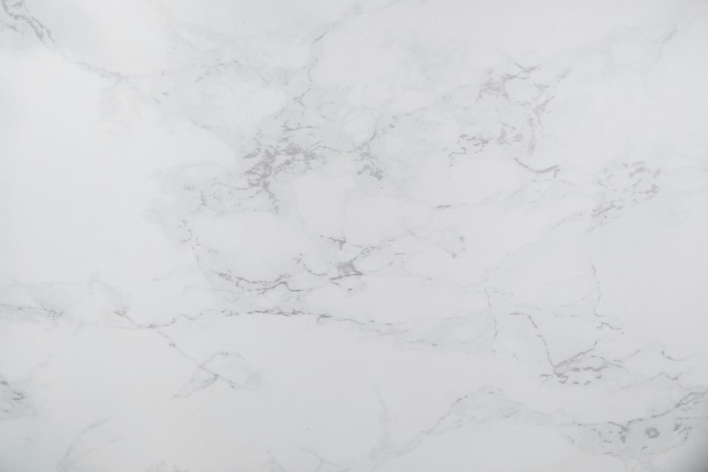 A close up of a white marble surface with natural veining.