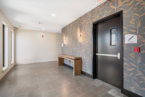 A hallway with a bench and a door.