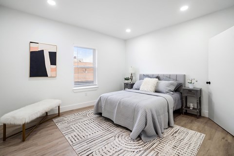 A bedroom with a large bed and a bench.