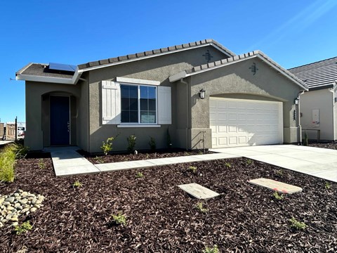 A house with a grey roof and a white garage door.