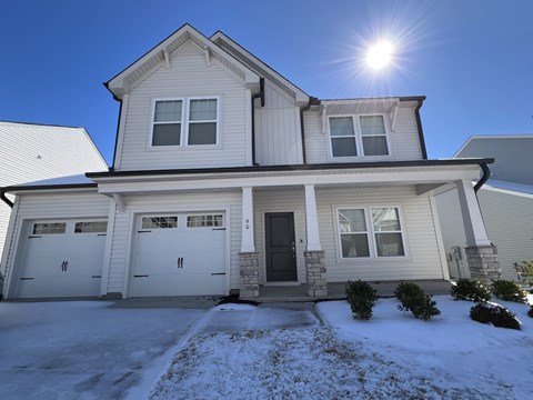 A house with a garage and a driveway covered in snow.