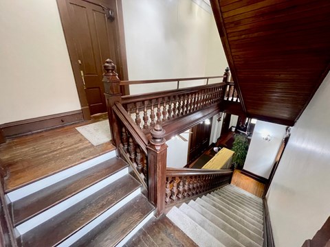 A wooden staircase with a metal railing.