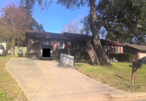 A house with a driveway and a mailbox in front.