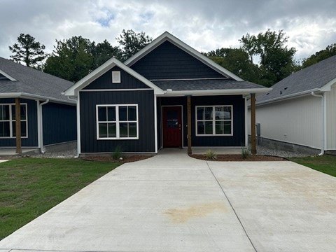 A blue house with a red door and windows.
