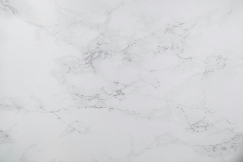 A close up of a white marble surface with natural veining.