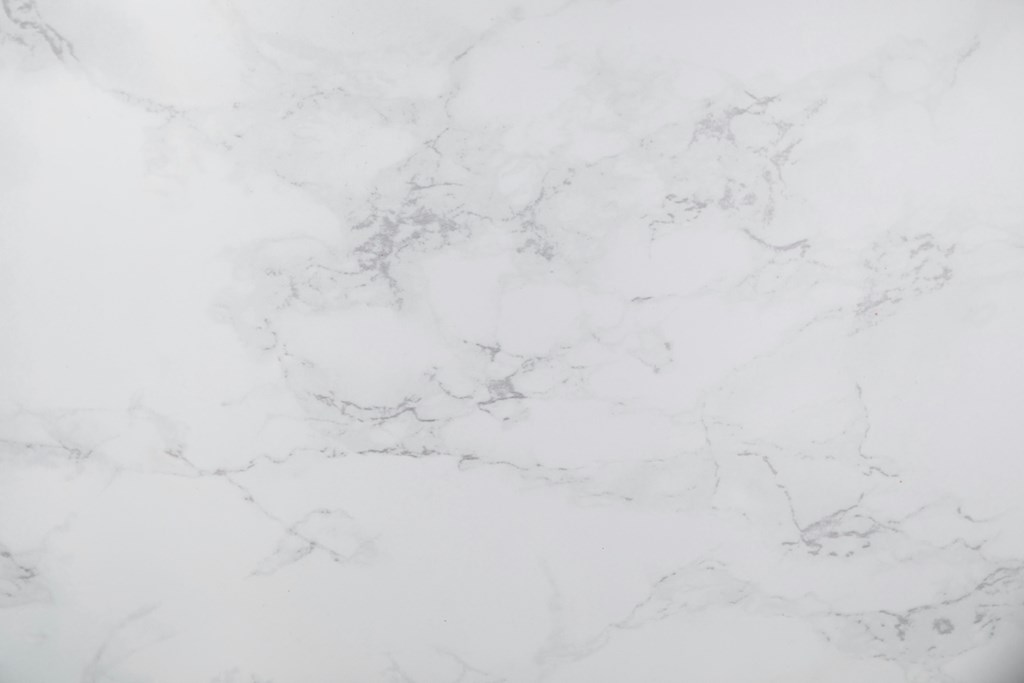 A close up of a white marble surface with natural veining.