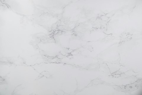 A close up of a white marble surface with natural veining.