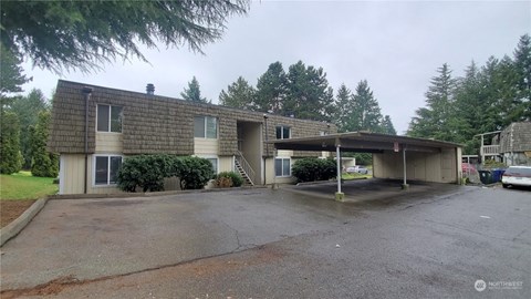 A house with a grey roof and a carport.