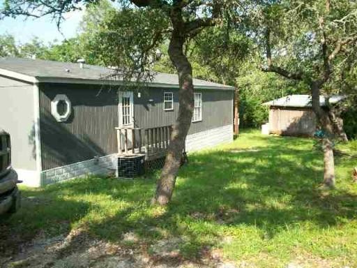 A grey house with a tree in front of it.