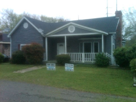 A house with a for sale sign in front of it.