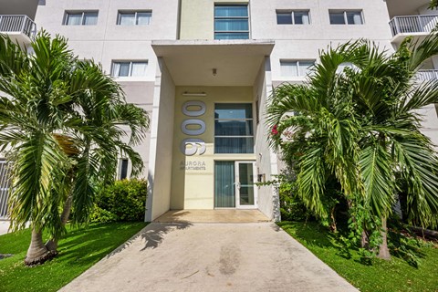 A white building with a green lawn in front.