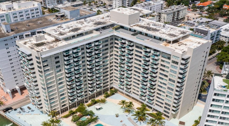 A large, multi-story building with a pool in front.