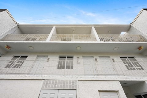 A white building with a flat roof and multiple windows.
