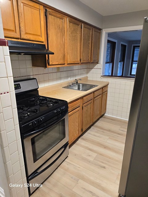 A kitchen with wooden cabinets and a black stove top oven.