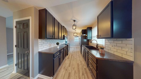 A kitchen with dark brown cabinets and a white tile backsplash.